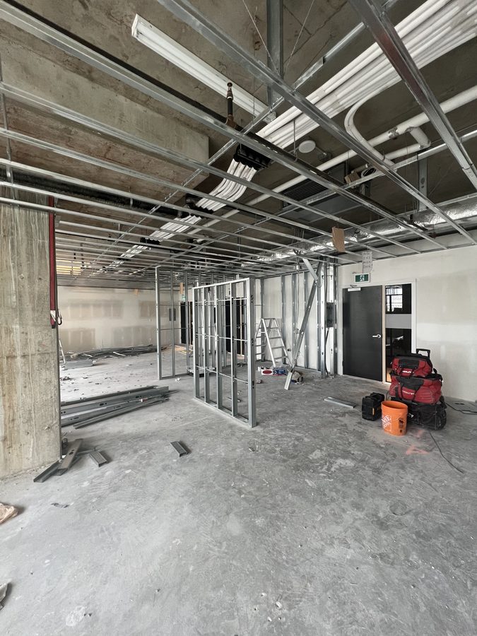 Steel stud ceiling and partition framing across a concrete floor