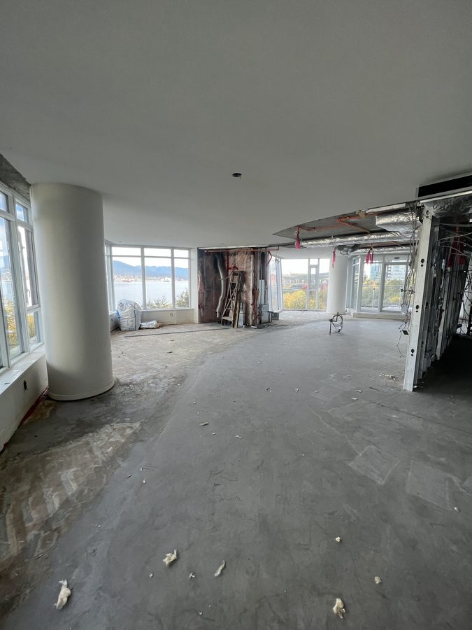 An open high-rise floor with round columns and windows, cleared for new framing