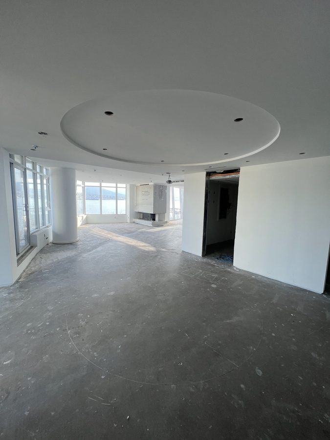 A finished round recess in a white drywall ceiling in a bright high-rise suite