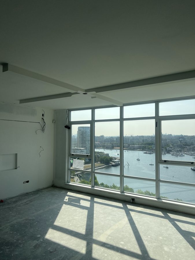 Drywall bulkheads in a high-rise suite above floor-to-ceiling windows with a marina view
